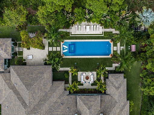 Custom in ground pool with stone tile patio inside a lanai from CoastLife Pools South Florida